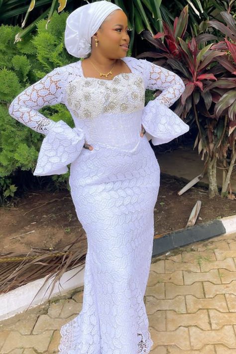 A lady wearing a white lace gown White Lace Gown Styles For Ladies, White Lace Styles For Ladies, Lace Gown Styles 2023, White Lace Styles In Nigeria, Dry Lace Gown Styles Nigerian, White Lace Gown Styles Nigerian, Trendy Lace Asoebi Styles, Latest Lace Gown Styles, White Lace Styles