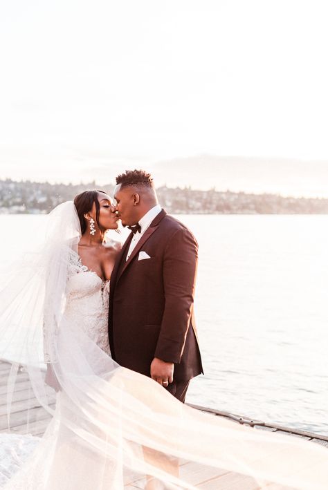 Romantic sunset wedding photos at a Nigerian American wedding on the Lake Washington waterfront boardwalk at Hyatt Regency Lake Washington, bride and groom kissing with lake in background and bride's veil in foreground sweeping across the left and bottom of the frame. Photo by Alisha Trahms Photography. Romantic Sunset Wedding, Seattle Waterfront, Sunset Wedding Photos, Seattle Wedding Photography, Lake Washington, Romantic Sunset, Washington Wedding, Waterfront Wedding, Editorial Wedding