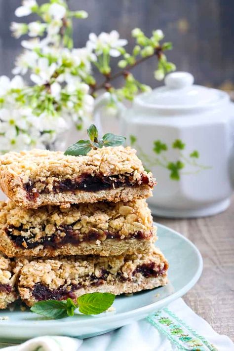 Three date bars stacked on top of each other on a green plate with a tea pot and white flowers in the background Old Fashioned Date Bars Recipe, Raspberry Oat Bars, Oat Squares, Raspberry Crumble Bars, Raspberry Crumble, Date Squares, Date Bars, Crumble Bars, Danger Zone