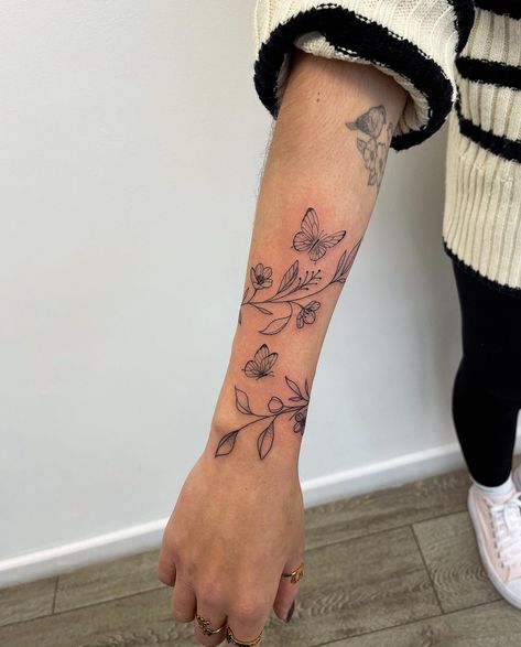 Tattoo Ideas Female Top Of Arm, Forearm Vine Wrap Tattoo, Vines On Forearm Tattoo, Roman Numeral Arm Tattoos For Women, Floral Wrap Around Tattoo Upper Arm, Flower Pelvic Tattoo, Iris Arm Tattoo, Simple Sleeves Design Tattoo, Medium Size Tattoos For Women Arm