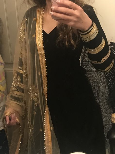 Elegant punjabi suit in black velvet with golden laces on arms and golden embroidered dupatta. Black Velvet Dress With Dupatta, Golden Dupatta Suit, Black Velvet Kurti Design, Design For Velvet Suit, Black Velvet Suit Design, Golden Dupatta Designs, Suit With Golden Dupatta, Golden Lace Design On Suits, Black Plain Suit With Heavy Dupatta