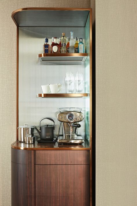 A hotel bar and espresso set up, with one shelf holding an array of liquors, the second shelf holding glasses, and the bottom holding a nice silver espresso machine, electric tea kettle, and a bucket for ice. Hotel Room Coffee Station, Hotel Room Mini Bar, Mini Bar Hotel, Hotel Coffee Station, Hotel Minibar, 2025 Design, Tiny Luxury, Classic Hotel, Luxembourg Gardens