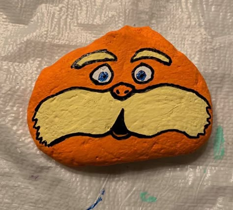 Lorax Painting Ideas, Painted Rock Aesthetic, Orange Rock Painting, Long Rock Painting Ideas, Cute Simple Rock Painting Ideas, Dr Seuss Painted Rocks, Things To Paint On Rocks Aesthetic, Cute Painted Rocks Ideas, Rock Painting Ideas Easy Aesthetic