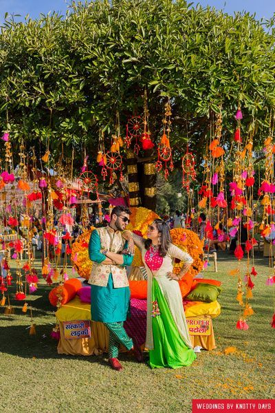 Mehendi Decor - Hanging Pom Poms From Tree Decor | WedMeGood  #wedmegood #indianwedding #indianbride #indiangroom #decor #mehendidecor #diy #hanging Mehendi Decorations, Pelli Decoration, Mehendi Decoration, Pohela Boishakh, Arabian Party, Small Stage, Sangeet Decor, Hall Decorations, Mehendi Decor Ideas