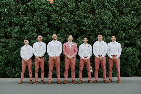 groom with his groomsmen all wearing coral Groom Attire Pink, Pink Suit Groomsmen, Coral Groom Suit, Pink Wedding Groomsmen, Groomsmen Summer Attire, Groomsmen Pink Attire, Coral Suit Men, Groomsmen Pink, Coral Groomsmen Attire