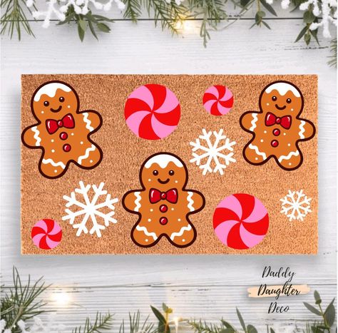 Welcome the holiday spirit with our charming Gingerbread Wonderland Doormat! Featuring delightful gingerbreads, festive peppermint swirls, and delicate snowflakes, this doormat is the perfect addition to your Christmas porch decor.  𝐏𝐫𝐨𝐝𝐮𝐜𝐭 𝐈𝐧𝐟𝐨𝐫𝐦𝐚𝐭𝐢𝐨𝐧 Our door mats are completely hand painted and sealed with a protectant spray. Each design is carefully placed, painted and preserved! Since each mat is hand painted colors and placement may slightly vary. Our welcome mats have a Door Mat Ideas Diy Rugs, Door Mat Christmas Diy, Christmas Door Mat Ideas Diy, Christmas Rugs Outdoor Diy, Christmas Rug Painting Ideas, Hand Painted Door Mats, Door Mat Painting Diy, Christmas Doormat Ideas, Christmas Doormat Diy