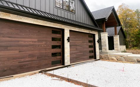 Barndo Garage Door, Mountain Modern Garage Doors, Dark Garage Doors Brick House, Dark Wood Garage Doors, Brown Garage Doors Ideas, Modern Wood Garage Door, Double Garage Door Ideas, Walnut Garage Door, Dark Garage Doors