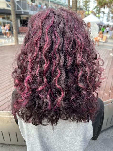 Cool Hair Color For Curly Hair, Curly Skunk Highlights, Peak A Boo Highlights Curly Hair, Magenta Highlights Curly Hair, Purple Highlights In Brown Hair Curly, Pink Peekaboo Hair Curly, Purple Peekaboo Highlights Curly Hair, Brown Hair Pink Highlights Curly, Chunky Pink Highlights Curly Hair