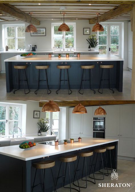 This traditional farmhouse has been paired with a contemporary painted kitchen design using the Elegant range from Sheraton. The island feature is a striking centrepiece in Oxford Blue combined with copper handles and seating for five. Incorporating an induction hob with a down draft extractor, this simple but effective design is complemented by on-trend copper lighting and accessories.  #sheratonkitchen #farmhousekitchen #countrykitchen #traditionalkitchen #kitchenislands Kitchen With Hob On Island, Kitchen Island Induction Hob, Kitchen Range In Island, Island Hob Kitchen, Rustic Kitchen Island With Stove, Range Island Kitchen, Range In Island Kitchen Layout, Kitchen Island With Electric Stove, Island Range Kitchen