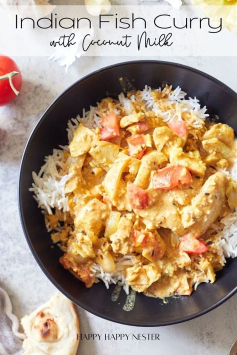 A bowl of Indian fish curry with coconut milk is served over white rice, garnished with diced tomatoes. A slice of naan bread and a cherry tomato can be seen in the background. The text "Indian Fish Curry with Coconut Milk" is displayed at the top. Indian Fish Curry, Fish Curry Indian, Curry With Coconut Milk, Fish Curry Recipe, Brunch Desserts, Delicious Seafood Recipes, Coconut Milk Recipes, Coconut Sauce, Coconut Milk Curry