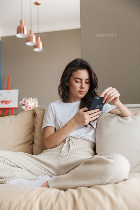 Beautiful young brunette woman relaxing on a couch at home by vadymvdrobot. Beautiful young brunette woman relaxing on a couch at home,one using mobile phone #Sponsored #woman, #relaxing, #brunette, #Beautiful Woman Looking At Phone, Woman On Couch, Easy Minecraft Houses, Brunette Woman, Long Hair Women, Taking Pictures, Couch, Long Hair Styles, Hair Styles