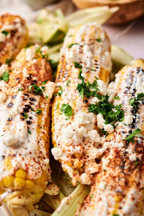 Grilled Mexican corn on the cob, reminiscent of Mexican Street Corn, topped with white sauce, crumbled cheese, chili powder, and cilantro. Best Mexican Street Corn Recipe, Mexican Corn On The Cob, Easy Mexican Street Corn, Corn In The Oven, Mexican Street Corn Recipe, Easy Side Dishes, Street Corn Recipe, Mexican Side Dishes, Mexican Corn