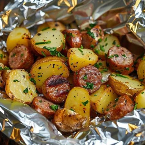 Sausage & Potato Foil Packet is a delicious and easy-to-make meal that perfectly combines savory sausages with tender potatoes and flavorful seasonings. This dish is not only satisfying and comforting, but it also has a versatile history that can be traced back to various culinary traditions around the world. From campfire cooking to backyard barbecues, this recipe has become a favorite among food enthusiasts due to its simplicity and fantastic flavors. This dish pairs wonderfully well with a si Sausage Foil Packets For The Oven, Sukkot Meals, Peanut Butter Brownie Trifle, Hobo Packets, Hobo Packs, Kielbasa And Potatoes, Cheesy Baked Chicken, Hobo Dinners, Foil Packet Potatoes