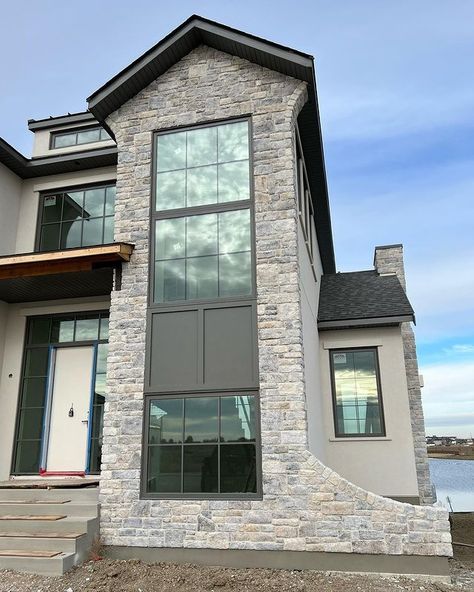 Modern and timeless – this gorgeous stone exterior house is guaranteed to leave you in awe! 🏠 #ixlbuild Product: Grand Banks Limestone | Eldorado Stone 📷: Tavares Masonry Modern Chimney Ideas Exterior, Eldorado Stone Grand Banks Limestone, Manufactured Stone Veneer Exterior, Loire Valley Eldorado Stone, Grand Banks Limestone, Grey Stone Exterior, Limestone House Exterior, Limestone Exterior, Stucco And Stone Exterior