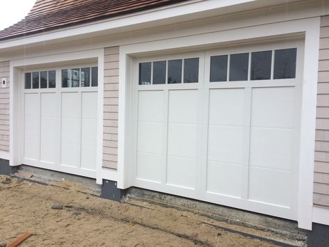 We installed two Haas American Tradition series carriage house garage doors for this new construction project in Barnstable. These are well-insulated steel doors with a woodgrain texture, composite overlays, and tempered glass windows. Garage Door Trim Exterior, Double Garage Doors Ideas, Shaker Style Garage Doors, Overlay Garage Doors, Haas Garage Doors 600 Series, Haas Garage Door, Raised Panel Garage Doors With Windows, White Garage Doors With Windows, Insulated Garage Doors With Windows