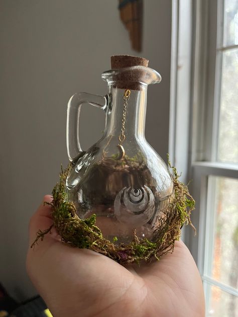 Fairy Bottles for any witchy, gothic, fairy-loving person! These bottles are made from moss, bottles, beads, chains, and glass armour. A great addition to any home.  Video on how it is made:  https://youtu.be/9KPvtRpJbbQ?feature=shared https://youtu.be/hZkWfI7NwVE?feature=shared Green Witch House Decor, Fairy Core Gift Ideas, Fairy Forest Decor, Fairy Core Home Decor, Cute Glass Bottles, Fairy Goth Decor, Witchy Decor Ideas, Glass Bottles Aesthetic, Fairy Core Diy