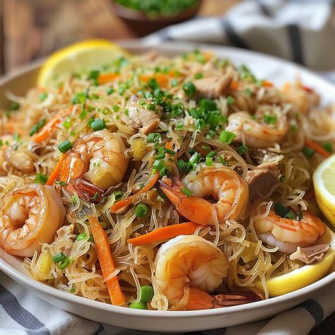 🍜 Relish the flavors of Pansit Bihon, a Filipino noodle dish! 🍤✨ #PansitPerfect #NoodleLove Pansit Bihon Ingredients: Rice noodles (1 lb) Chicken breast, sliced (1 cup) Shrimp, peeled and deveined (1 cup) Carrots, julienned (1 cup) Cabbage, shredded (1 cup) Soy sauce (1/4 cup) Garlic, minced (3 cloves) Onion, sliced (1) Chicken broth (2 cups) Lemon (for garnish) Instructions: Soak rice noodles in water until soft. In a pan, sauté garlic and onion. Add chicken and shrimp, cook until done. ... Pansit Bihon, Filipino Noodles, Instagram Recipes, Noodle Dish, Chicken And Shrimp, Trending Recipes, Noodle Dishes, Rice Noodles, Chicken Broth