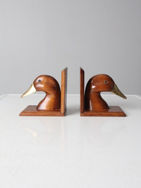 "This is a pair of vintage duck bookends. Wood and brass shape the classic bookend pair. CONDITION In good condition with wear consistent with age and use. Some scratches to the wood (primarily on the base). MEASUREMENTS Height: 5.25\" .. 13.3 cm Width: 4.25\" .. 10.8 cm Depth: 5.5\" .. 14 cm 121978" Vintage Plane Nursery, Bookends Wood, Duck Bookends, Cabin Renovation, Wooden Duck, Vintage Duck, Dream Nurseries, Vintage Clothing Online, Baby Boy Rooms