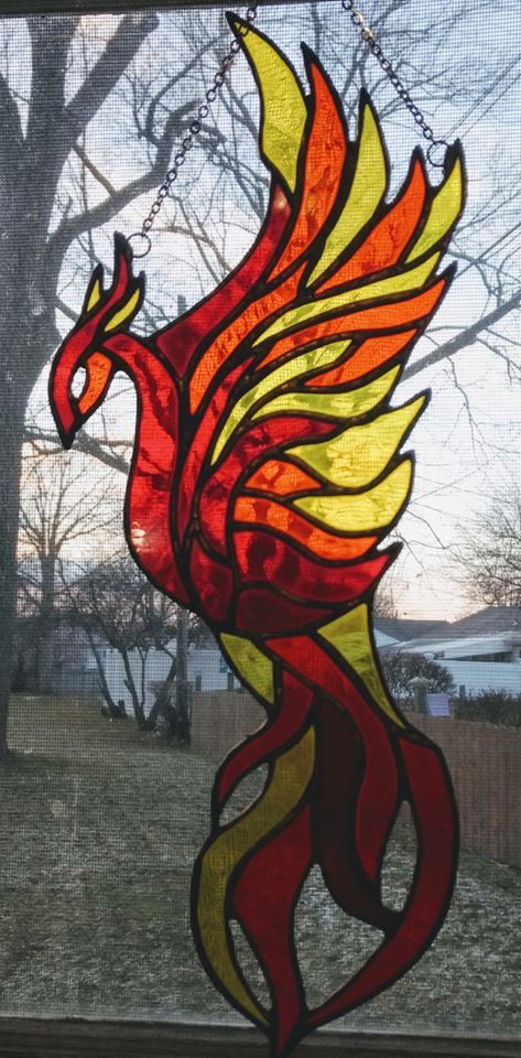 This is a long stained galss suncatcher. About 14 inches long. It is also available in peacock colors.  It is made with stained glass and reinforced with copper restrip. Stained Glass Phoenix Bird, Phoenix Stained Glass Pattern, Stained Glass Fire, Bird Mosaics, Book Edges, Booklet Cover, Glass Suncatchers, Peacock Colors, Stained Glass Ornaments