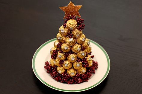 Ferrero is a candy and confection company that produces elegant-looking truffles. One of the company's top-sellers is Ferrero Rocher. The Rocher candy begins with a whole hazelnut that is covered with creamy chocolate. The outside of the candy is coated in wafer pieces with another layer of smooth chocolate. All this is captured in a decorative... Ferrero Rocher Christmas, Ferrero Rocher Tree, Ferrero Rocher Gift, Candy Trees, Chocolate Tree, Brunch Buffet, Ginger Snap Cookies, Truffle Recipe, Tree Shop