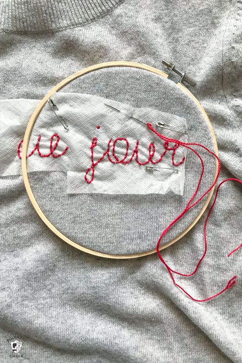 Learn how to make a DIY Embroidered sweater with a fun french quote on it. Includes free embroidery pattern for the quote. A clever way to refashion an old sweater. #DIYEmbroidery #DIYFashion #embroideredsweater #tutorial Embroidery In Sweater, Embroidering Sweatshirts Diy, Chain Stitch Name Sweater Diy, Embroidering A Sweater, How To Embroider A Sweater, Hand Embroidery On Sweater, Embroidery Names On Clothes, Yarn Embroidery On Sweater Diy, Diy Embroidered Sweater