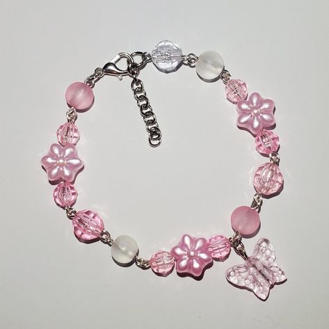 7.25 in with 1 in extender. Can add or remove beads to adjust sizing. Pink glass butterfly charm, acrylic pink flower beads and acrylic beads. Lobster claw clasp. Fairy Garden Aesthetic, Butterfly Bead Bracelet, Simplistic Jewelry, Butterfly Accessories, Fairy Bracelets, Accessories Board, Flower Charm Bracelet, Diy Kandi Bracelets, Fav Products