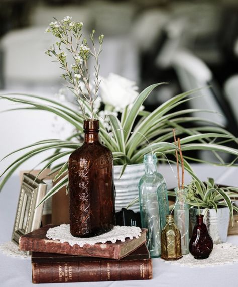 Small Bottle Centerpieces, Vintage Bottles Wedding Centerpieces, Antique Bottle Centerpieces Wedding, Vintage Book Wedding Decor, Antique Book Centerpieces, Spider Plant Centerpiece Wedding, Antique Wedding Centerpieces, Books Centerpiece Wedding, Nonfloral Centerpiece Ideas