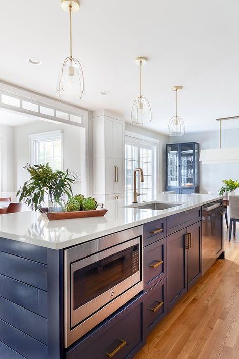 Long blue kitchen island with mixed metals designed with a white quartz countertop, brass pulls and stainless steel appliances. Blue Kitchen Island, Rustic Wood Floors, Elegant Kitchen Design, Hale Navy, Long Kitchen, White Shaker Cabinets, Refinish Kitchen Cabinets, Kitchen Island With Seating, Studio Kitchen