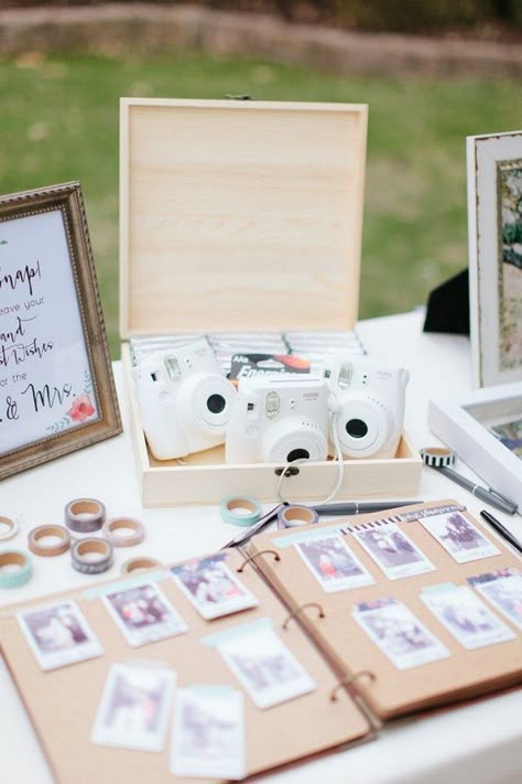 White polaroid cameras sit on a table above a sign in book where guests have taped photos of themselves and written well wishes Wedding Guest Book Table, Polaroid Wedding, Backyard Wedding Ceremony, Wedding Guest Book Unique, Guest Book Table, Signing Table Wedding, Wedding Guest Book Sign, Wedding Favors Cheap, בר מצווה