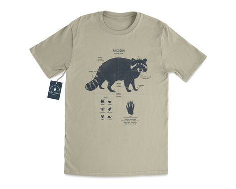 Wildlife anatomical design of the raccoon that's pressed with hand-mixed inks onto a velvety smooth cotton shirt. The shirt is twined and tagged giving a vintage nautical presentation. Makes a thoughtful gift for any raccoon enthusiast in your life. T-shirt stats: * 100% ringspun cotton * Unisex sizing * Shoulder taping * Side-seamed * Pre-shrunk All shirts are silk-screened here in the Life Shines workshop and because of the handmade nature, each t-shirt has a different "personality". All ink c Animal T Shirt Design, Cute Animal Shirts, Raccoon Clothes, Raccoon Anatomy, Nature Clothes, Raccoon Gift, Animal T Shirt, Raccoon Shirt, Vintage Nautical