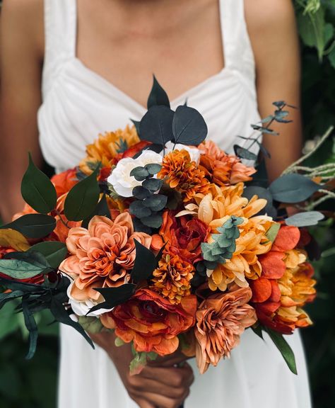 Stunning one of a kind bouquet. Featuring preserved eucalyptus/greenery and bold burnt orange, terracotta, marigold orange makes this bouquet enchanting and alluring for the bride to be. This Moody inspired bouquet will make a statement for a fall, Halloween, Gothic or moody inspired wedding.  Available with ribbon or twine wrapped base.  ❤️ Handmade in the USA with love & care ❤️ ✅ Wow your guests with this realistic classic one of a kind style ✅ Hassle free- ready to use wedding package right September Bridal Bouquet, Marigold Wedding Bouquet, Fall Wedding Bouquets October, Silk Flower Arrangements Wedding, Burnt Orange Wedding Bouquet, Marigold Bouquet, Burnt Orange Bouquet, Preserved Bridal Bouquet, July Wedding Flowers