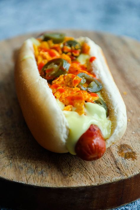 Nacho Cheese Dog - Cheesy, crunchy and hot is all you need for a great manwich experience. Nacho Cheese Dog is an American Style Hotdog Sandwich prepared with grilled Hotdogs topped with nacho cheese sauce, pickled jalapeno peppers and crushed tortilla chips. Now that we have Costco in Auckland American Hotdogs became easily accessible,... Hot Dog Nachos, Grilled Hotdogs, Eating Hot Dog Photography, Chili Cheese Hot Dog Boats, Unique Hot Dog Toppings, Chili Cheese Hot Dog, Hotdog Sandwich, Pickled Jalapeno Peppers, Nacho Cheese Sauce