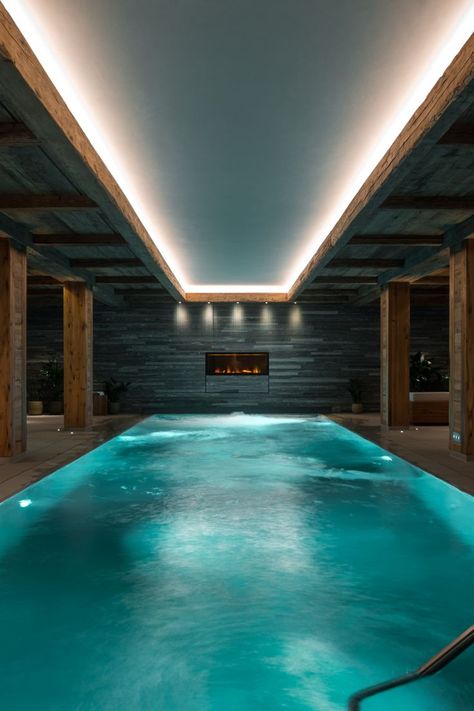 Indoor swimming pool with fireplace at one end. Underground Swimming Pool, Luxury Pools Indoor, Underground Pool, Outdoor Hot Tub, Indoor Pool Design, Luxury Wellness, Family Ski, Luxury Chalet, Garden Tattoo