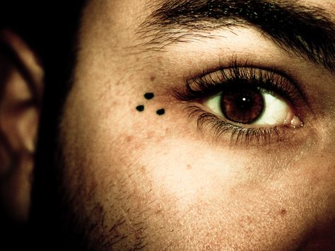 The three dots tattoo is a very common prison tattoo that symbolizes 'mi vida loca' or 'my crazy life.' It doesn't symbolize any particular gang, but rather the gang lifestyle. It's typically found on the hands or around the eyes. Three Dots Tattoo Meaning, Prison Tattoo Meanings, Dot Tattoo Meaning, 3 Dot Tattoo, Dotted Tattoo, Under Eye Tattoo, Tattoo On Face, Tato Mata, Triangle Tattoo Meaning