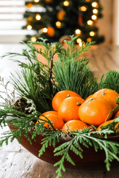 a close up of a wooden bowl filled with evergreens and oranges Decorating With Fruit For Christmas, Christmas Decor With Fruit, Citrus Christmas Centerpiece, Centerpiece With Oranges, Oranges With Cloves Decoration, White Christmas Floral Arrangements, Tree Decor Outdoor, Christmas Oranges, Orange Christmas Decor