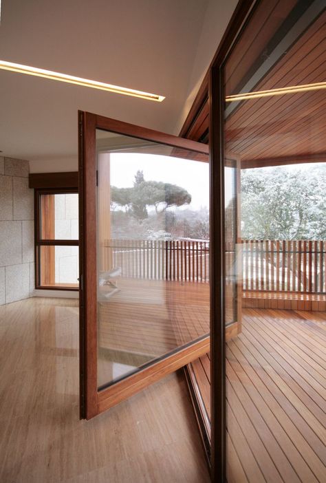 Large wood framed windows rotates open onto wooden front balcony. Studio Dwelling / cmA Arquitectos. Pivot Door, Garage Studio, Sliding Glass Doors, White Cottage, Window Door, Design Del Prodotto, Decoration Inspiration, Entrance Doors, Madrid Spain