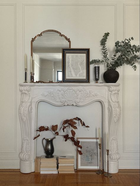 Elegant living room design showcasing a faux fireplace with a classic mantel, adorned with candles and decorative accents, embodying Parisian chic style. Layered Textiles, Mantel Styling, Antique Mantel, Parisian Decor, Curated Decor, Faux Fireplace, Decor Elements, Cast Stone, Fireplace Mantle