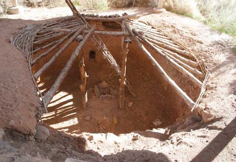 This is a recreation of an Anasazi Pit House in Mesa Verde, Colorado. Evidence of the subterranean quarters dates back to around 500 AD. These dwellings were shallow, around 3-5 feet deep. The roof canopy, usually flat, was held up generally by four posts- positioned upright whose structure join was joined at the top by four horizontal beams and crossed with ceiling joists. The exterior of the pithouse was made of branches, brush and grass held together with mud. Construction was completed with Pit House, Off Grid Survival, Bushcraft Shelter, Earth Sheltered, Survival Skills Life Hacks, Underground Homes, Indian Village, Survival Life Hacks, Bushcraft Camping