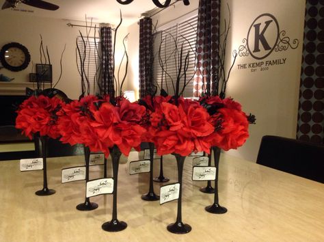 DIY Black and red wedding centerpieces. Can of spray paint, twigs, silk flowers and tea light stands. Enjoy!  (Note that most of this are dollar stores finds)   Materials used:  (12) Tea light stands  (they come in different sizes but mine was about 12 inches tall)  1 can of primer paint 1 can of clear gloss (optional) 1 can of spray paint   (your choice of color) I used charcoal black for this  (12) styrofoam balls  slightly bigger than the openings of your tea light  12 bunches of silk flowers Heavy Centerpieces, Black And Red Rose Wedding Decorations, Red And Black Centerpieces Diy, Red Black And Silver Centerpieces, Red Black And Silver Party Decoration Centerpiece Ideas, Black And Red Roses Party Decor, Red And Black Flower Centerpieces, Black Formal Red Roses Table, Red Wedding Centerpieces