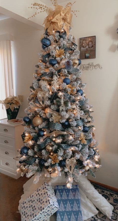 Blue/gold decorated Christmas tree . Blue and gold decor Flocked Christmas Trees Decorated Blue And Gold, Blue Flocked Tree, White Blue And Gold Christmas Tree, Christmas Tree Themes Colors Blue And Silver, Blue White Silver Gold Christmas Tree, Blue Gold And White Christmas Decor, Blue And Rose Gold Christmas Decor, Navy Blue Gold Christmas Tree, Blue Ornaments On Christmas Tree