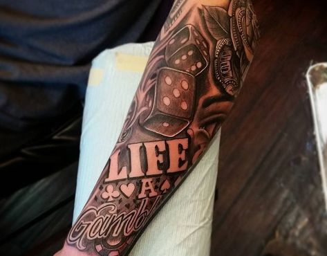 Do you believe that "life is a gamble"? Thinking of getting a tattoo as a reminder? Here are popular 'life's a gamble' tattoo ideas that you will love. @andywesttattooartist via Instagram 'Life is a gamble' tattoo represents risk-taking, stakes and uncertainty in life. Do you believe that living life's a… Life’s A Game Tattoo, Life’s A Risk Tattoo, Life S A Gamble Tattoo, Life A Gamble Tattoo Design, Life’s A Gamble Tattoo Arm, Game Of Life Tattoo, Lifes A Gamble Tattoo Forearm, Life Is A Gamble Tattoo Ideas, Life’s A Gamble Tattoo Design