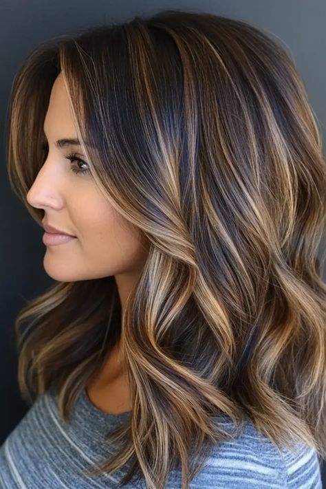 Woman with shoulder-length, wavy hair featuring caramel highlights. Hair Color Framing Face, Highlights On Brown Hair Medium Length, Medium Length Dimensional Brunette, Highlight For Brunettes, Brown Hair With Highlights Winter, Dark Hair With Lighter Highlights, Top Highlights Hair Brunettes, Brown With Minimal Highlights, Go Back To Natural Hair Color