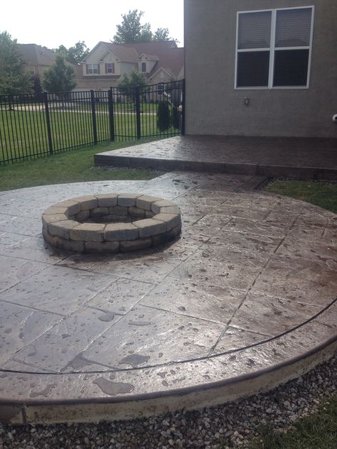 A beautifully designed Colored  Stamped Concrete Patio using a combination of earth toned colors with the addition of an adjoining circular fire-pit area makes this Powell, Ohio home ready for warm summer days or crisp fall evenings!! Round Stamped Concrete Patio, Concrete Pad Fire Pit Area, Stamped Concrete Fire Pit Area, Patio Color Ideas, Concrete Fire Pit Area, Stamped Concrete Fire Pit, Cement Fire Pit, Colored Stamped Concrete, Concrete Fire Pit