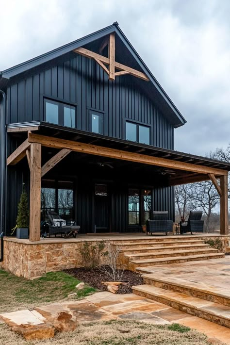 Modern barndominium house black shiplap exterior with dark wood beams. Check out the coolest dark barndominium houses that combine rustic charm with modern sophistication, enhancing a living space with bold hues and sleek designs. Dark Colored Barndominium, Dark Gray Barndominium Exterior, Barndominium Siding Ideas, Barndominium Black, Dark Barndominium Exterior, Dark Barndominium, Dark Modern Farmhouse Exterior, Shiplap Exterior, Black Barndominium Exterior