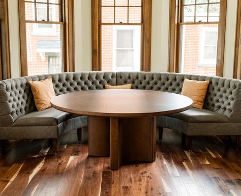 Banquettes have been growing in popularity and it's easy to see why. Their versatility makes banquettes a perfect fit for both cozy residential nooks and stylish commercial spaces.  This curved banquette that we recently built for our friends at CRI Designs features exposed legs and pulled tufting that adds to the elevated, naturally lit dining area. Dining Room Table With Couch Seating, Curved Dining Banquette, Curved Settee Dining, Dining Booths In Homes, Banquette With Round Table, Modern Banquette Seating, Round Banquette, Banquette Seating Dining Room, Curved Banquette Seating