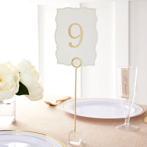 "Get the Style Me Pretty Gold Table Numbers, 1-25 at Michaels. com. Add some style and charm to your wedding table setting with these number cards from Style Me Pretty. Add some style and charm to your wedding table setting with these number cards from Style Me Pretty. You can team them with tealights or flowers to complement your wedding décor. Details: White with gold gilded edges 4.25\" x 5.75\" x 0.5\" (10.8cm x 14.61cm x 1.27cm) 25 number cards (1 through 25) Table tent construction Die-cut Wedding Table Numbers In Flowers, Guest Table Number Ideas, Large Table Numbers, Coastal Table Numbers Wedding, White And Gold Table Numbers, Wedding Table Number Sign, Tall Table Numbers Wedding, Wedding Diy Table Numbers, Wedding Table Number Ideas Elegant