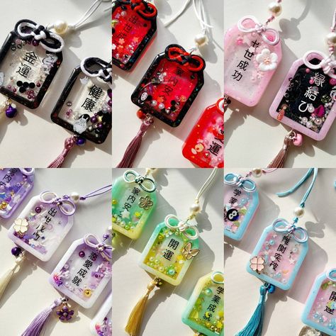 "Omamori (御守/お守り) are Japanese amulets commonly sold at Shinto shrines and Buddhist temples, dedicated to particular Shinto kami as well as Buddhist figures, and are said to provide various forms of luck and protection. Handmade resin shaker omamori available as mystery pouch or to be pick out. These are to be hanged in a room or rearview mirror inside the car. Not recommended to be carried around. If you want a mystery omamori pouch, simply pick out the \"mystery\" option. If you like a certain Shinto Kami, Japanese Omamori, Seni Resin, Shaker Charm, Buddhist Temples, Inside The Car, Keychain Design, Cute Keychain, Art Tutorials Drawing