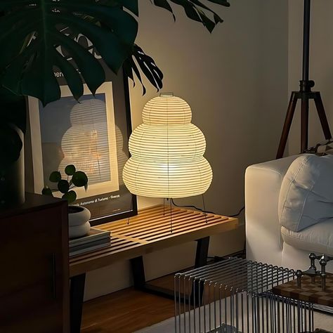 Transform any space into a serene retreat with the Noguchi Lamp. This lamp effortlessly blends modern minimalism with Japanese-inspired elegance. Crafted with care, it features a rice paper lampshade that emits a gentle, ambient glow, while the stainless steel light stand adds a contemporary touch. Perfect for illuminating your living room, study, bedroom, or bedside, this lamp exudes sophistication and charm. With its handmade craftsmanship and timeless design, the Noguchi Lamp is a stylish add Bedroom Ceiling Light Fixture, Lamp Inspiration Living Room, Japanese Inspired Apartment Decor, Noguchi Lamp Bedroom, Small Bedroom Lamps Bedside Tables, Japanese Home Bedroom, Japanese Modern Decor, Lamp On Kitchen Table, Japanese Rice Paper Lamp