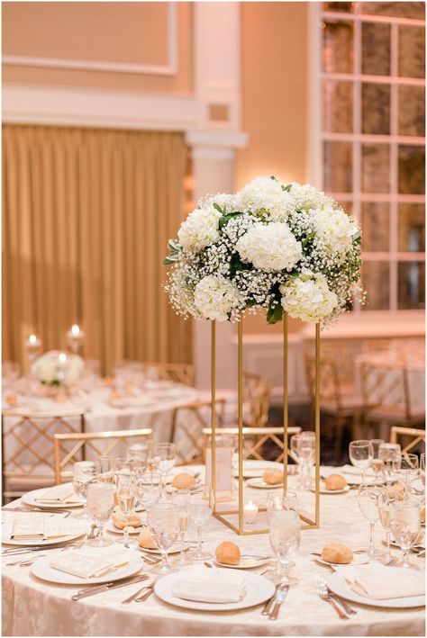 White Gold Wedding Reception Decor, Gold Stand Centerpiece Wedding, White And Gold Wedding Florals, Tall Gold Stand Centerpiece Wedding, White And Gold Flower Centerpieces, Tall White Centerpieces Wedding, Gold Stand Centerpiece, Tall Flower Centerpieces, Timeless White Wedding