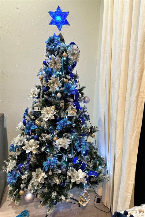 I have adopted a Christmas custom and applied it to Hanukkah. Our tree is adorned with Hanukkah-related decorations, white lights, and blue ribbons. I even added in silver and blue poinsettias. After all, it is the festive time of year. Hanukkah Tree Ideas, Hanukkah Tree Decorations, Hanukkah Tree, Hannukah Decorations, Jewish Celebrations, Christmas Custom, Silver Decor, White Lights, White Christmas Tree